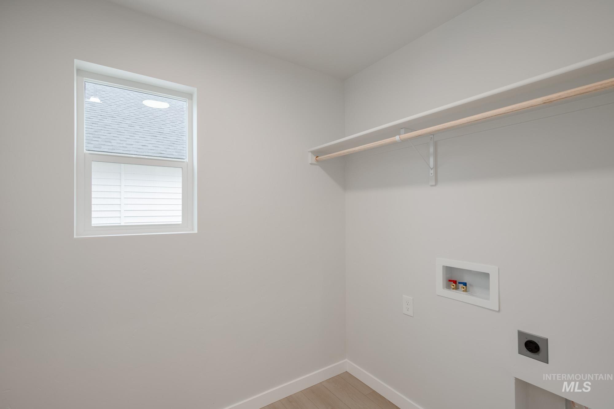 Washroom featuring light wood finished floors, hookup for a washing machine, and hookup for an electric dryer