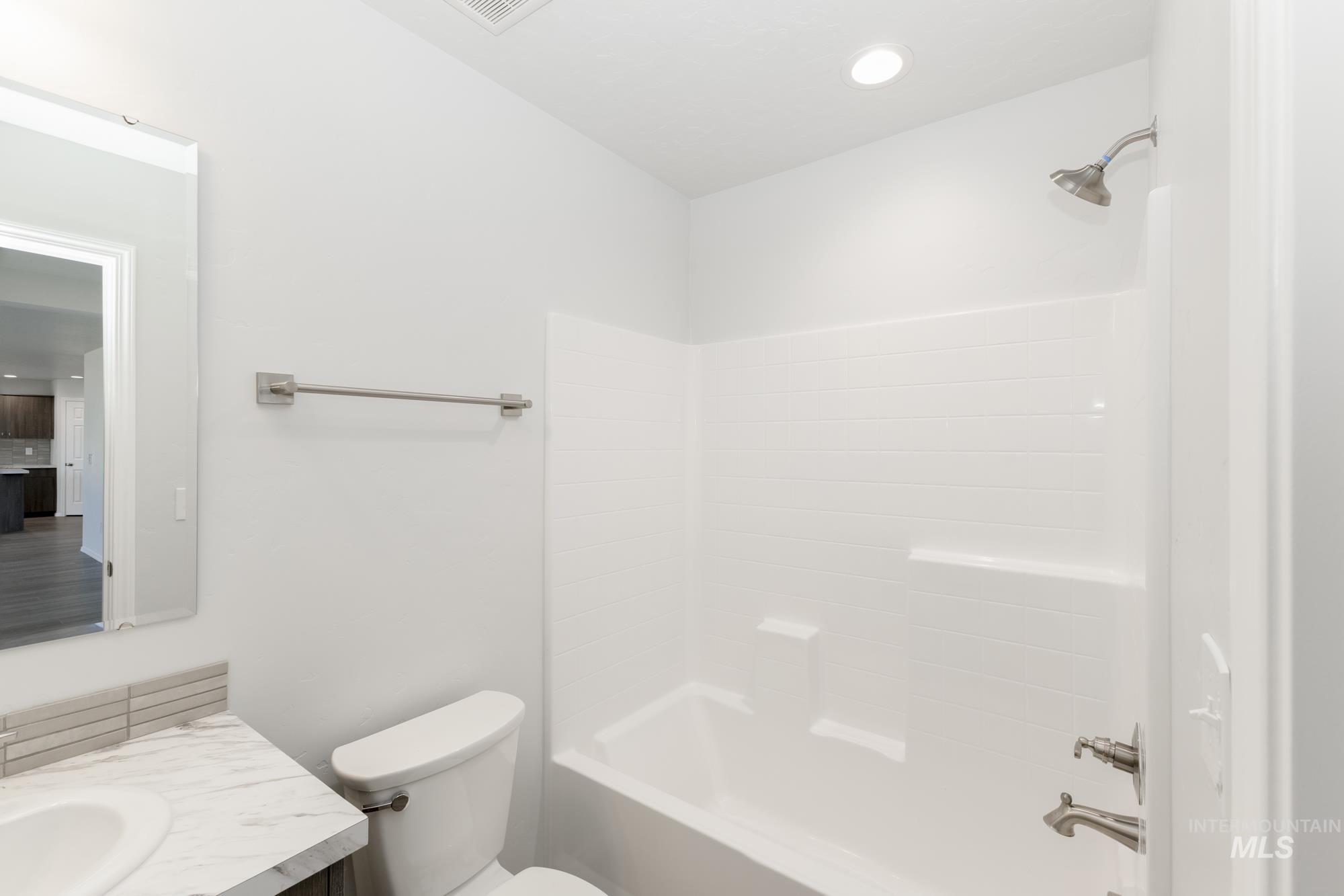 Full bath with shower / bath combination, vanity, and recessed lighting