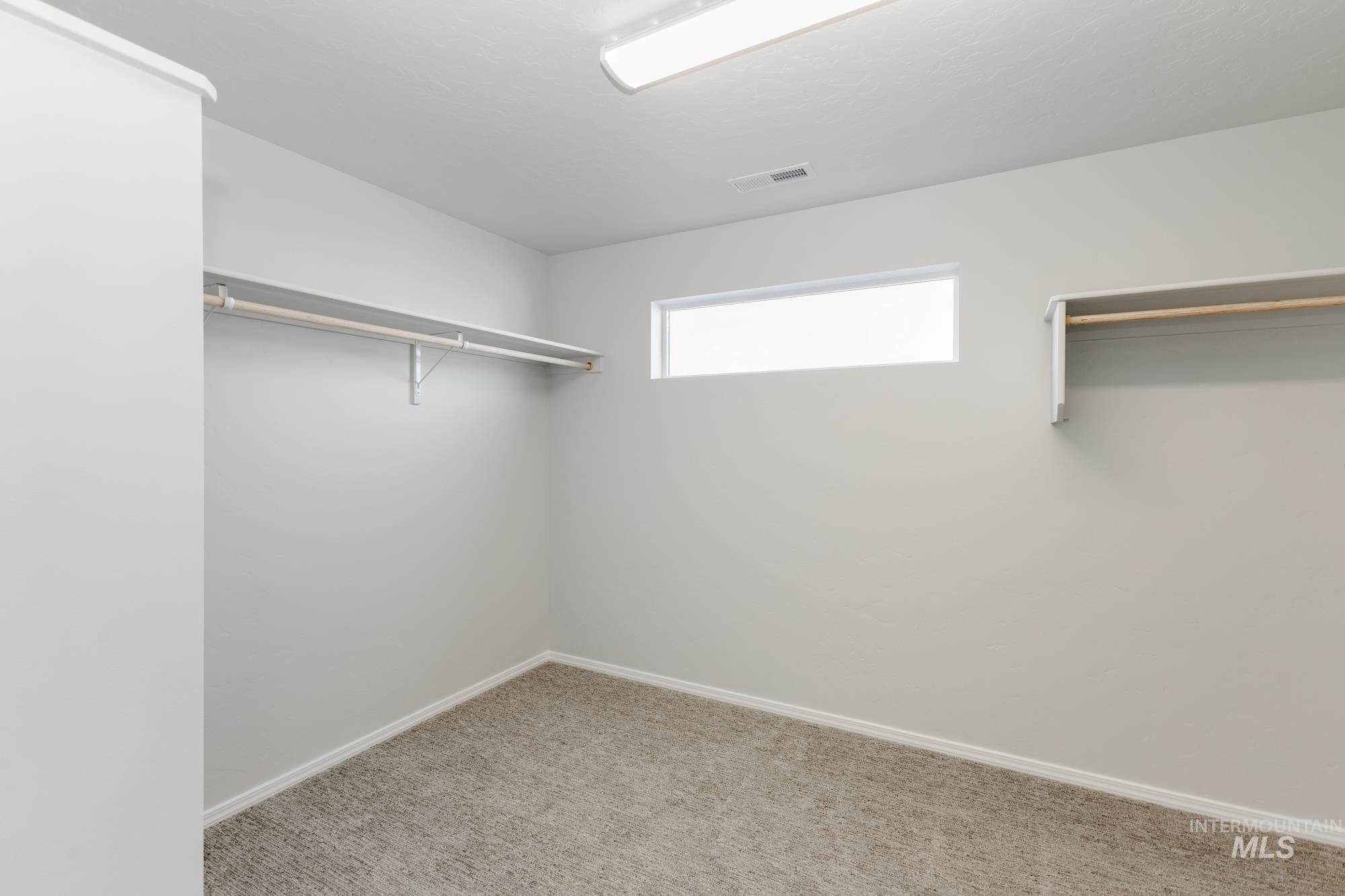 Spacious closet with light colored carpet