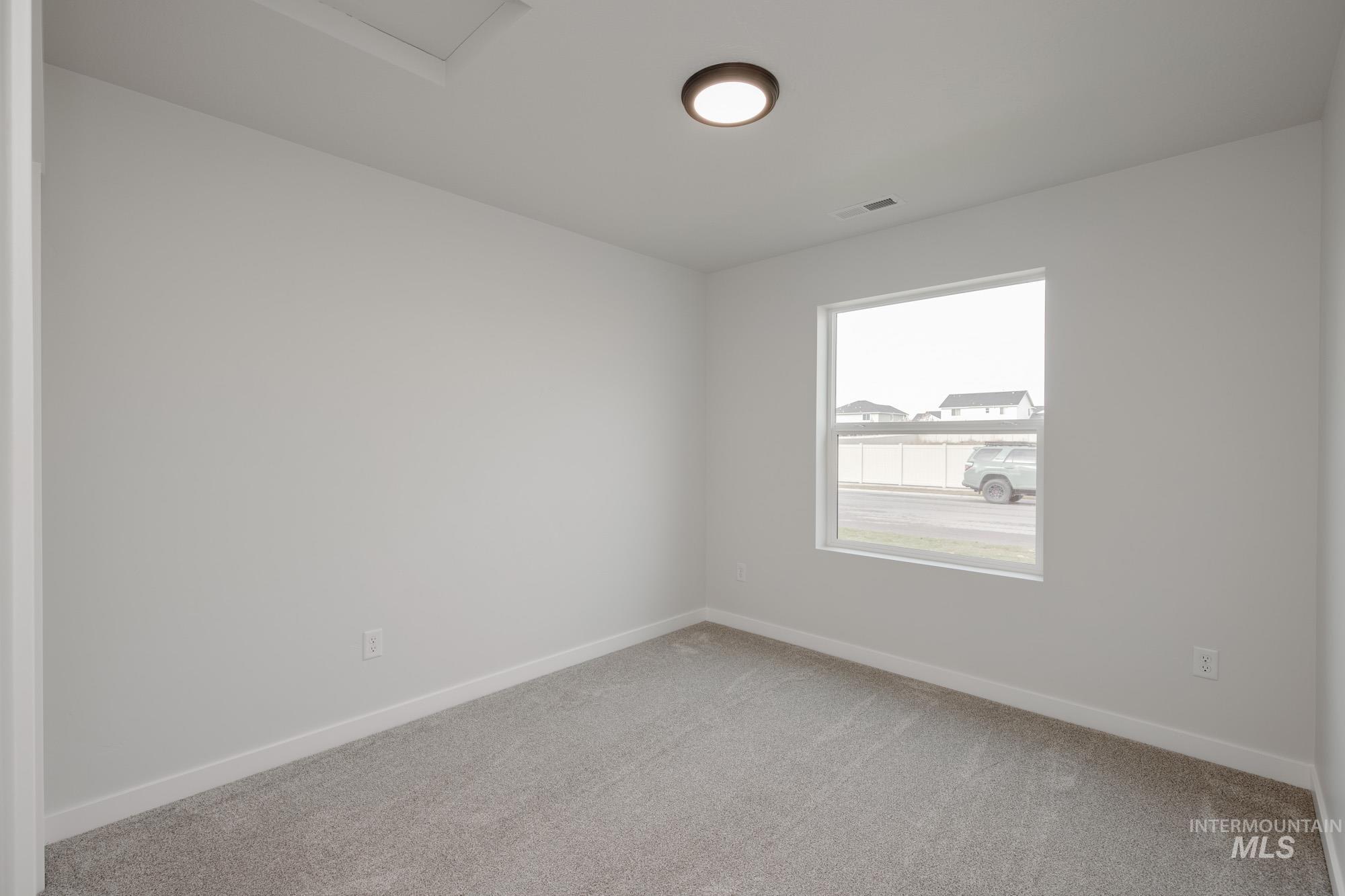 Empty room featuring baseboards and light colored carpet
