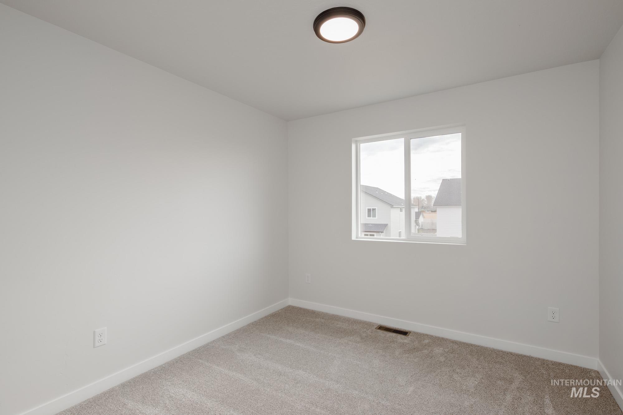 Carpeted empty room with baseboards
