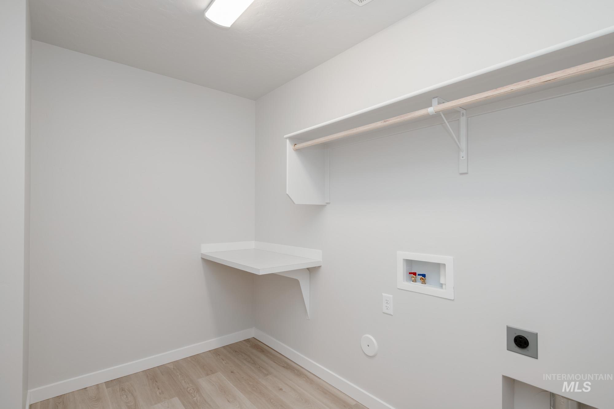 Laundry area featuring washer hookup, light wood-style flooring, and electric dryer hookup