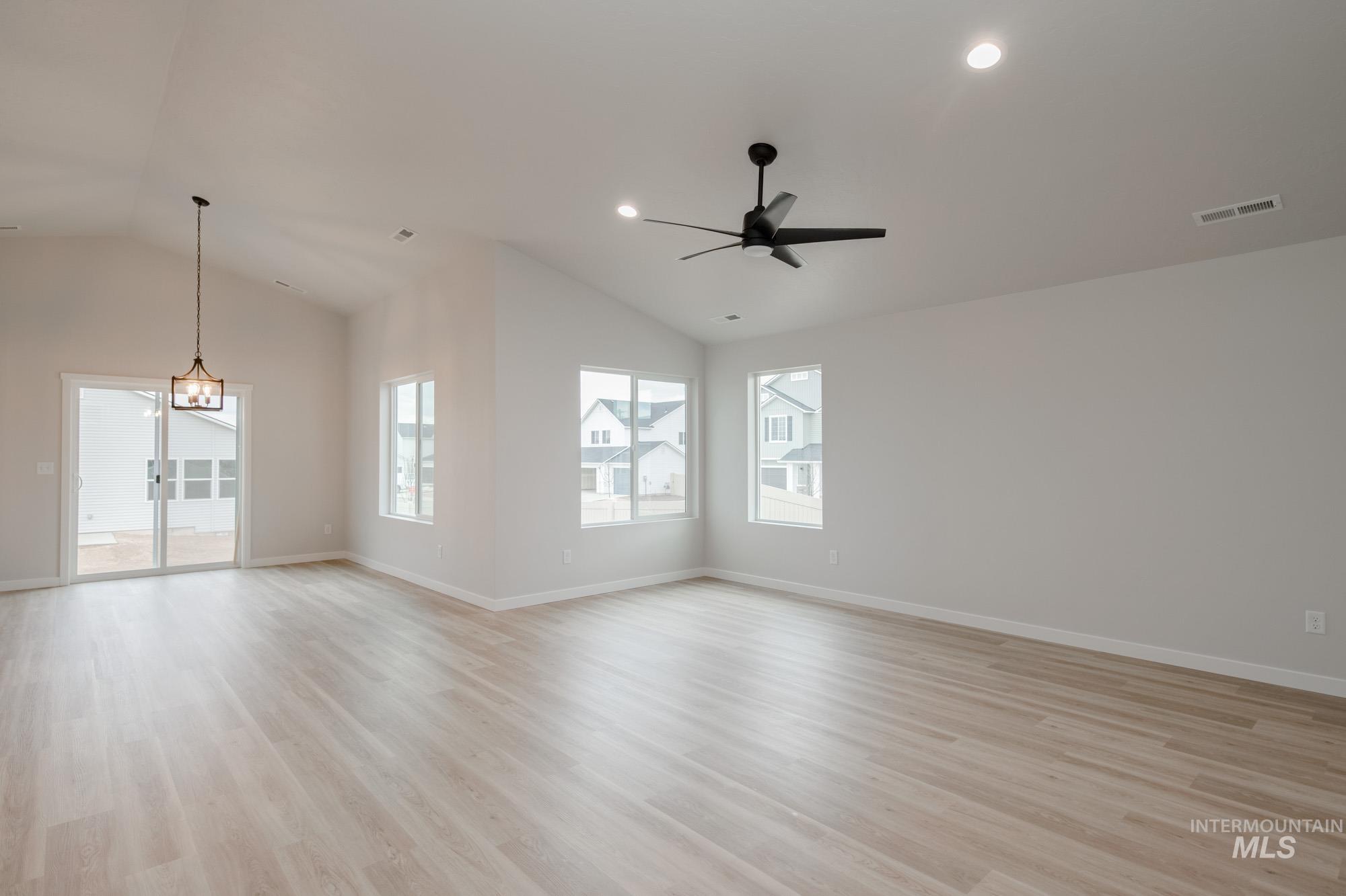 Spare room featuring vaulted ceiling, light wood-style floors, ceiling fan, and recessed lighting