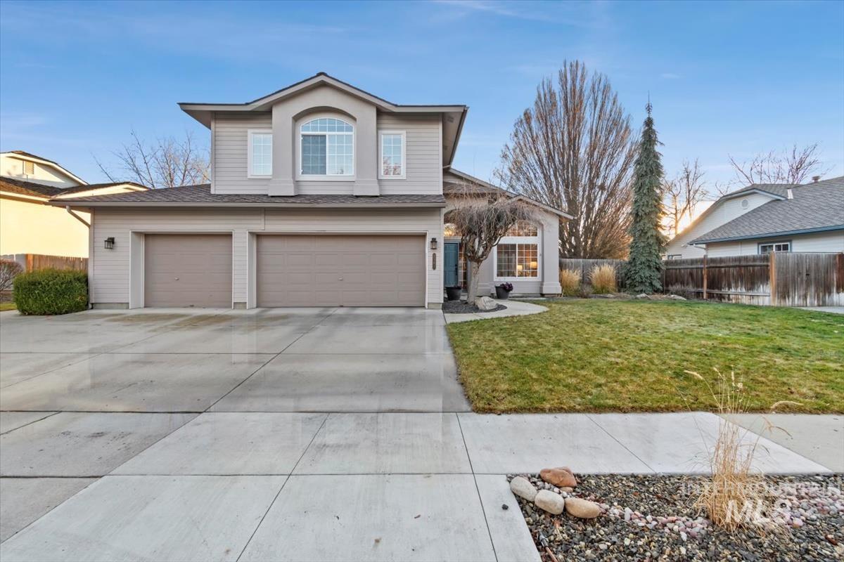 Traditional-style house featuring an attached garage and driveway