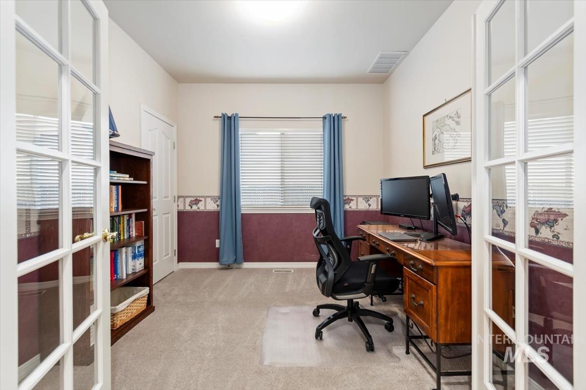 Office area featuring light colored carpet, french doors, and wainscoting
