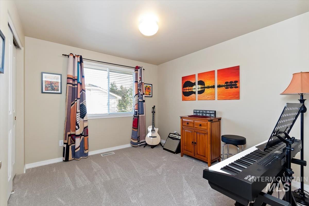 Exercise area featuring light colored carpet and baseboards