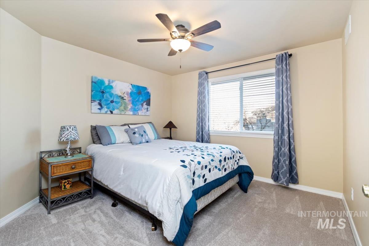 Bedroom featuring light carpet and a ceiling fan