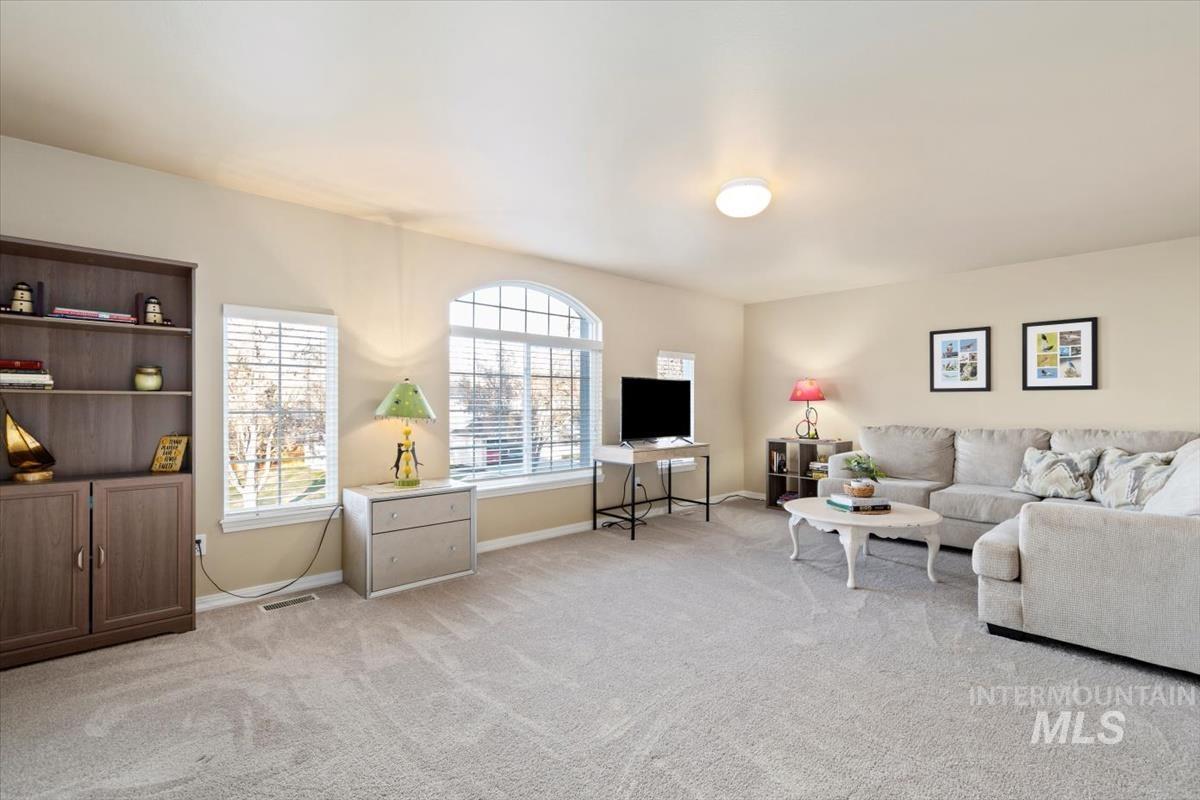 Living area featuring light carpet and baseboards