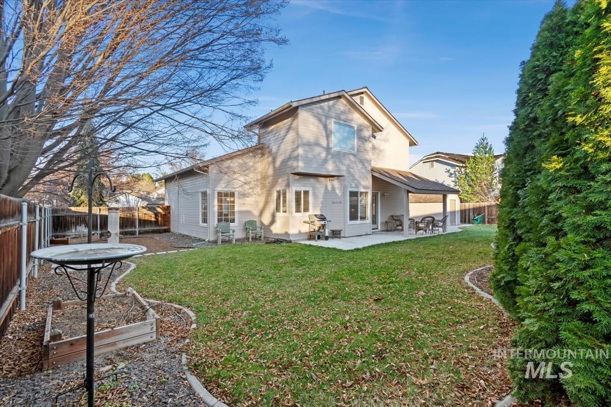 Rear view of house with a fenced backyard, a patio, and a garden
