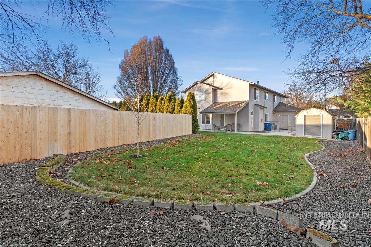Rear view of house featuring a patio area, a fenced backyard, and a storage unit