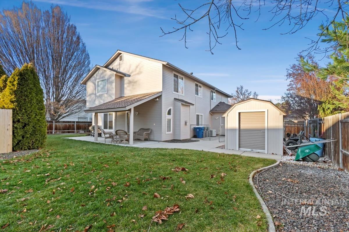 Back of house featuring a patio, a storage unit, and a fenced backyard