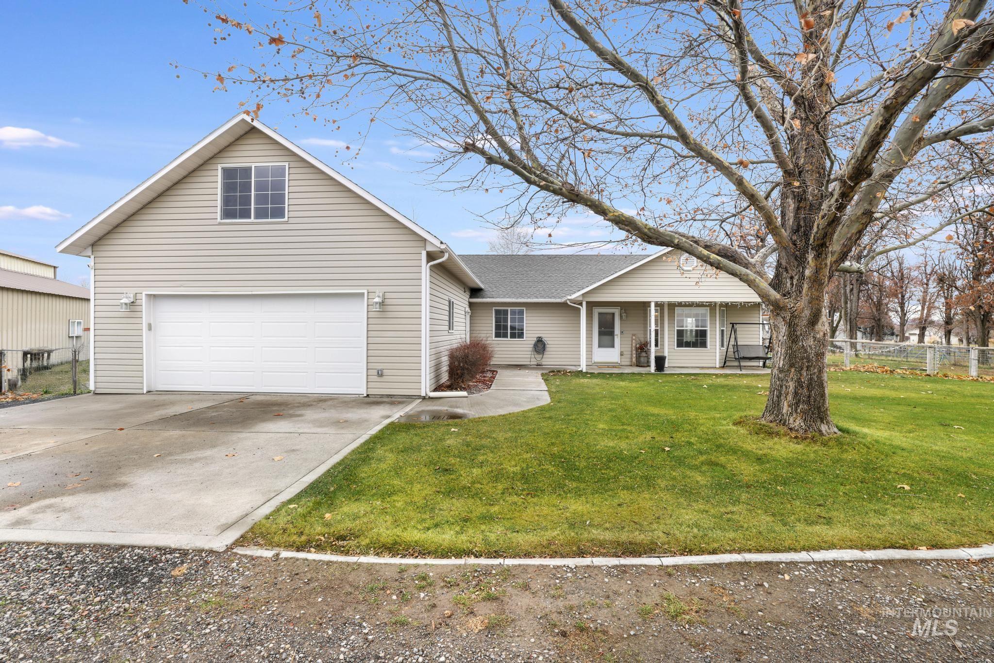 Traditional-style home with a garage, concrete driveway, and a porch