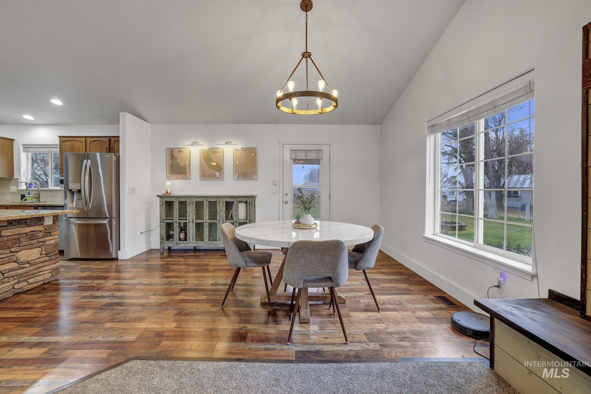 Dining area with dark wood-style flooring, lofted ceiling, a chandelier, and recessed lighting