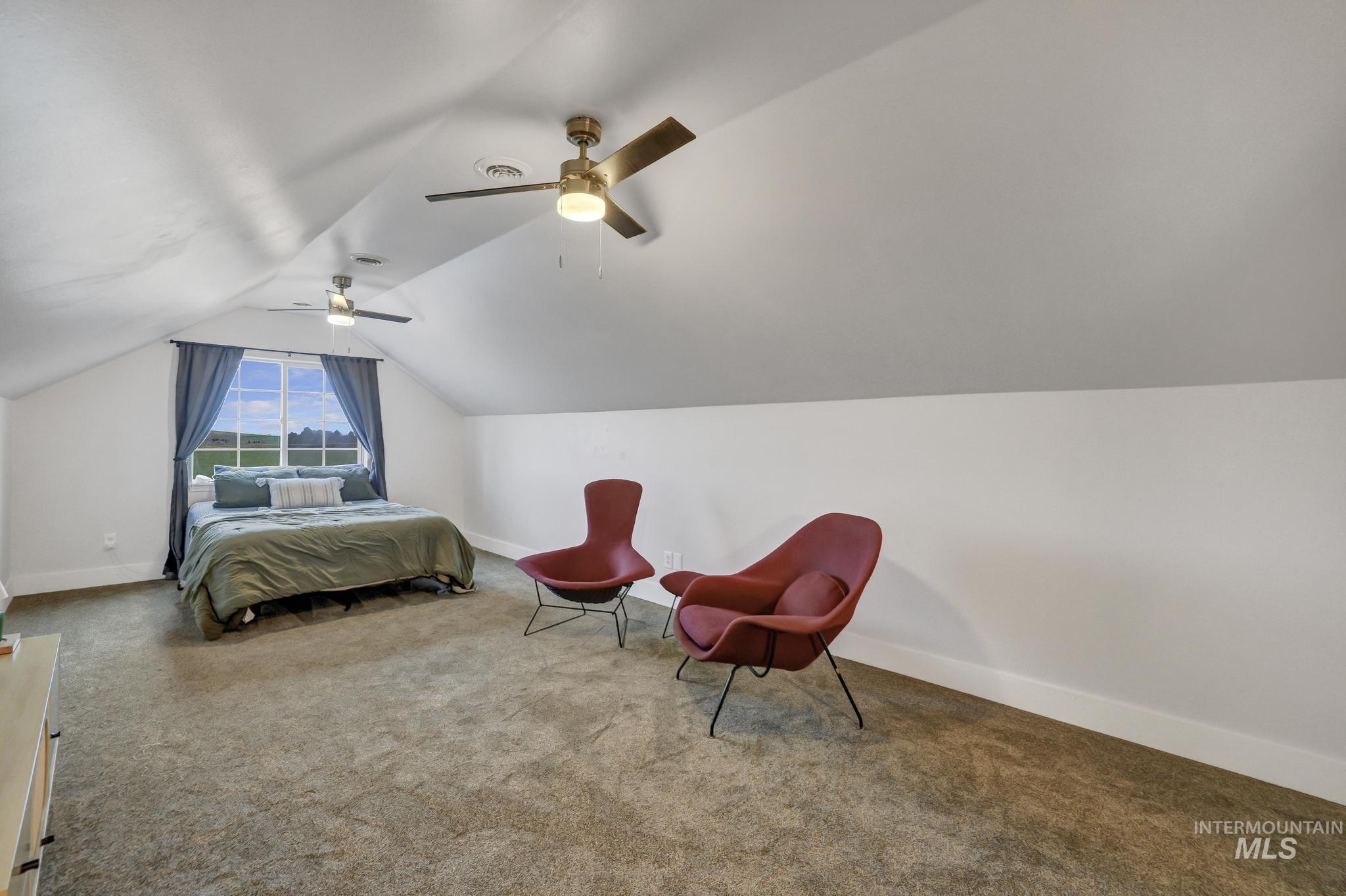 Bedroom featuring carpet flooring, lofted ceiling, and ceiling fan