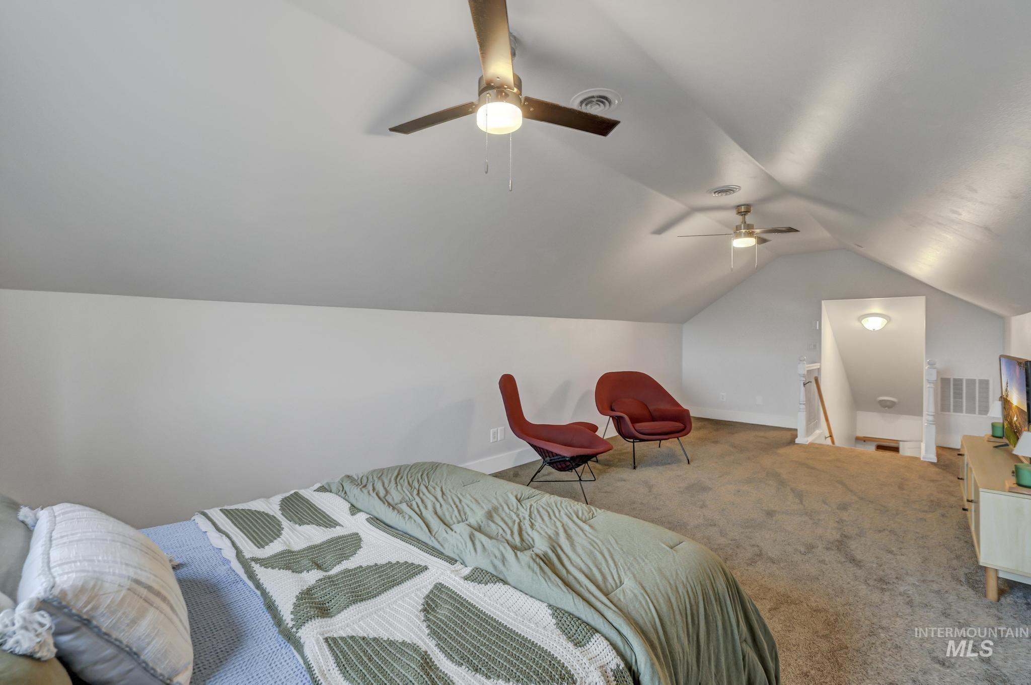 Bedroom featuring vaulted ceiling, carpet, and a ceiling fan
