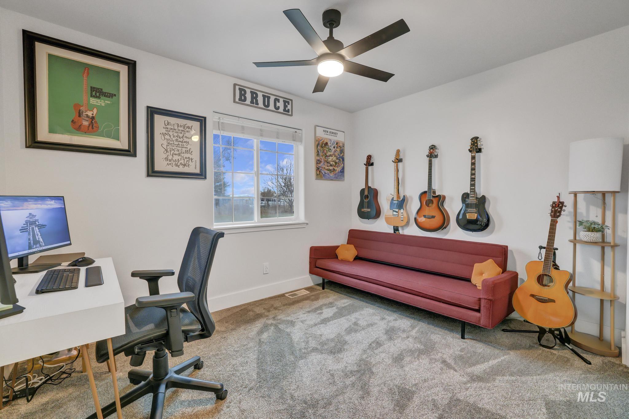 Carpeted office space featuring baseboards and ceiling fan