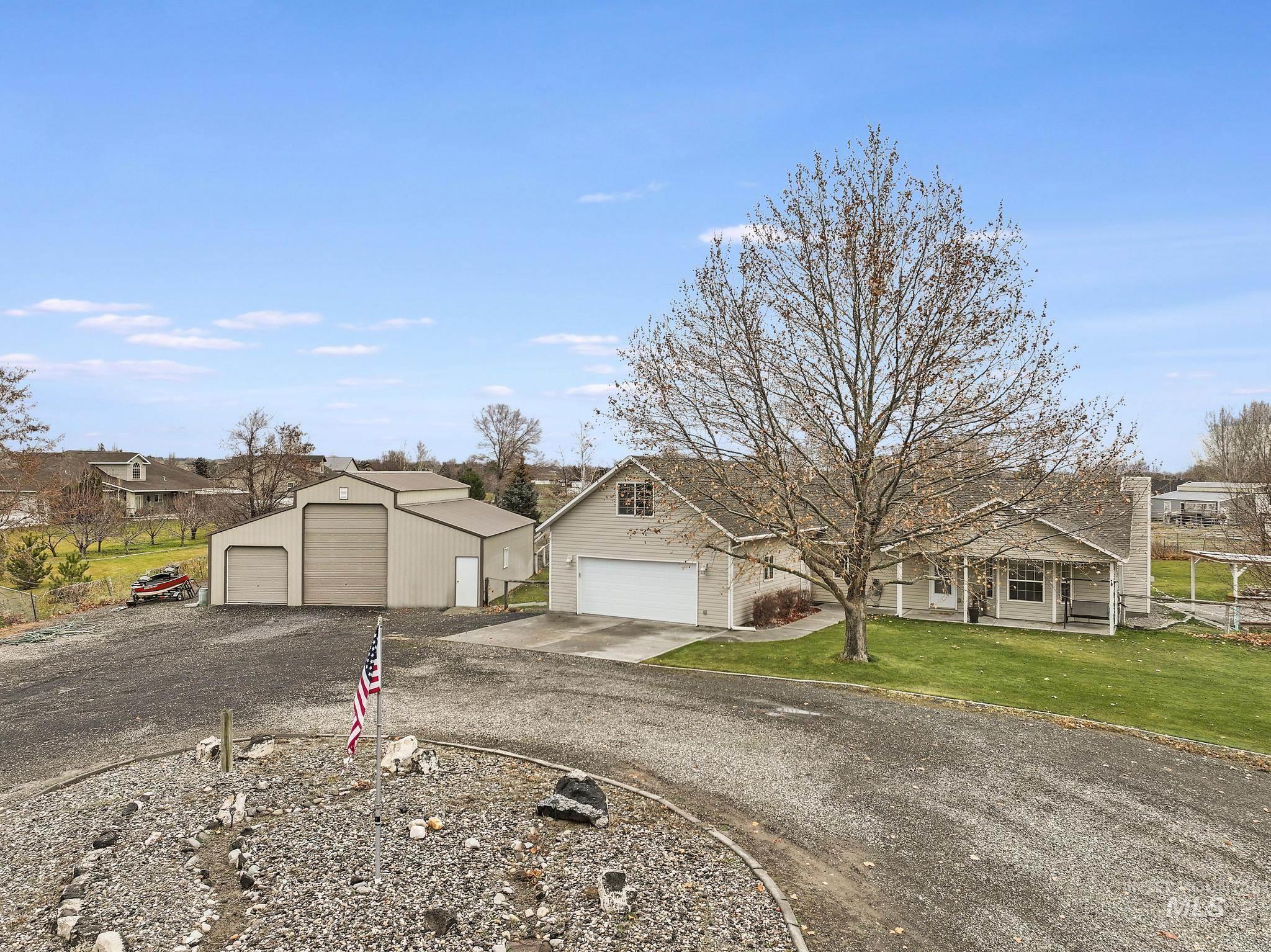 View of front of home featuring a residential view, a front lawn, and a detached garage