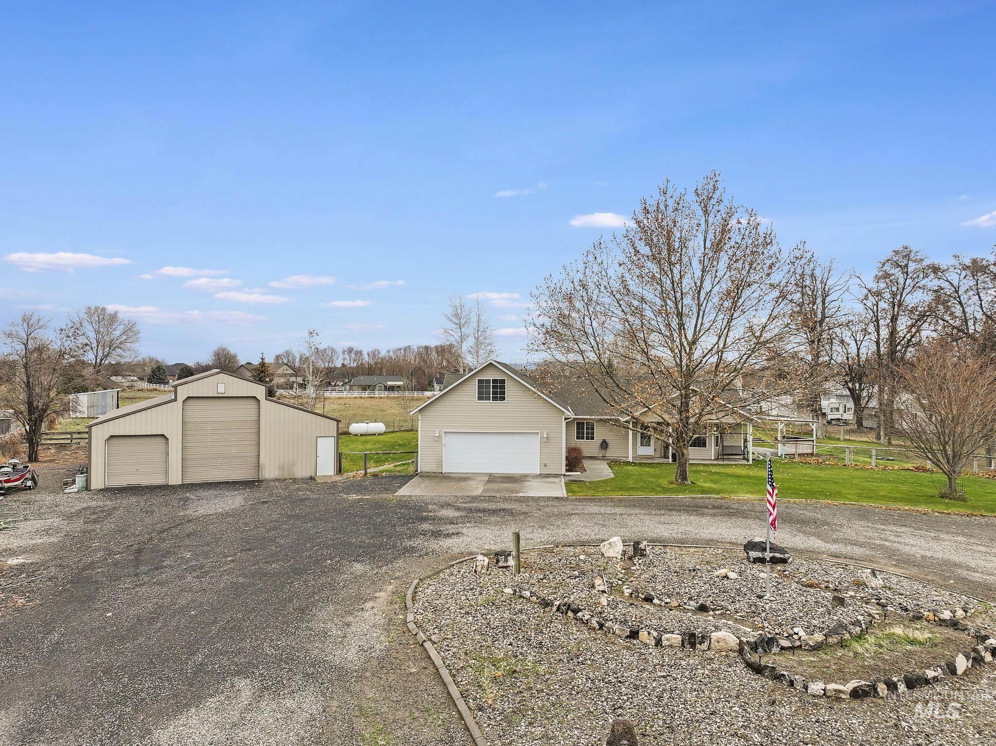 View of front of property with a front yard, a garage, and an outbuilding