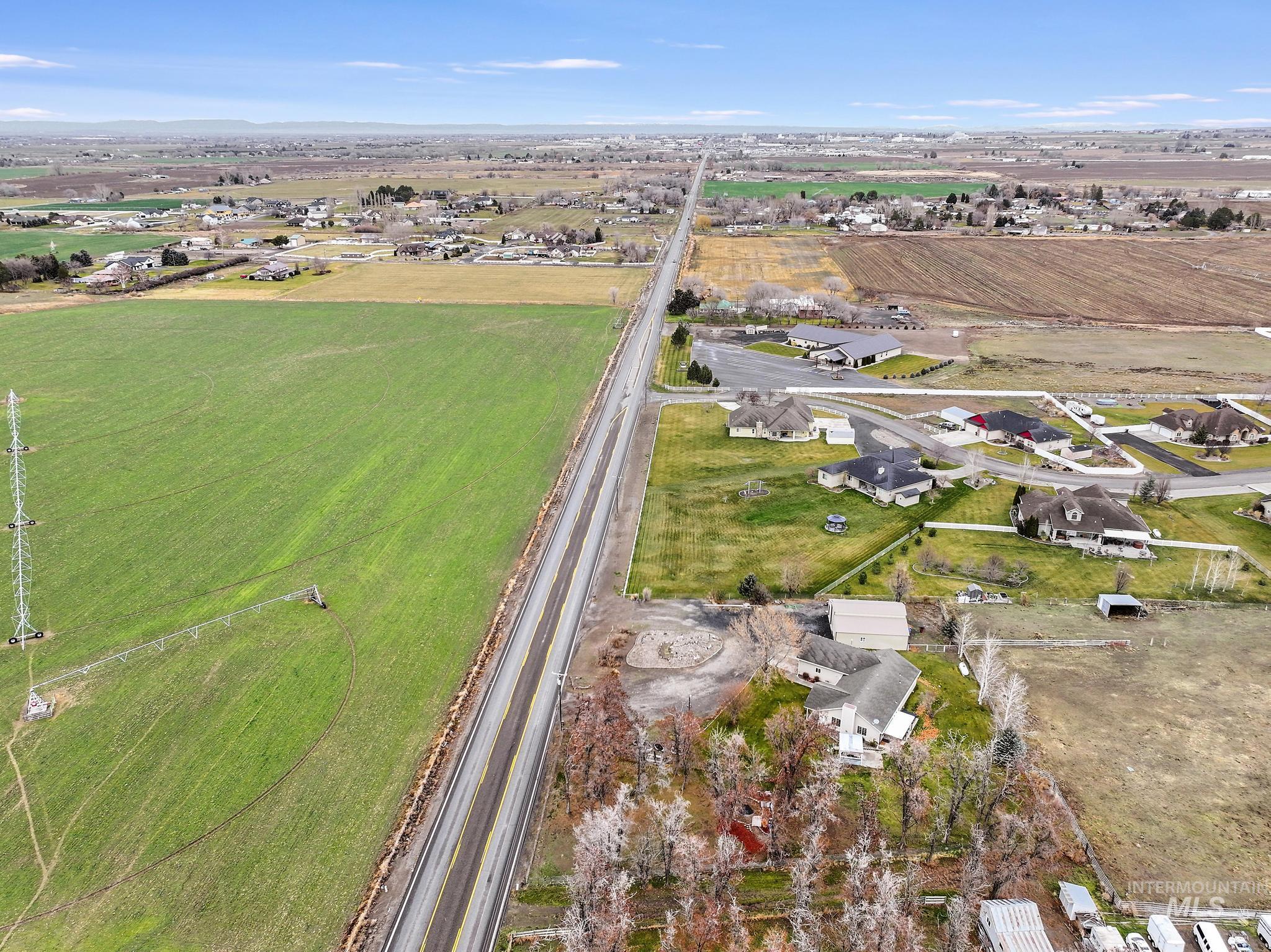 Aerial view of property and surrounding area with rural landscape and large plots for crops