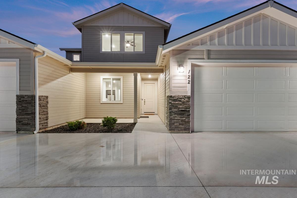 View of front of house with board and batten siding and driveway