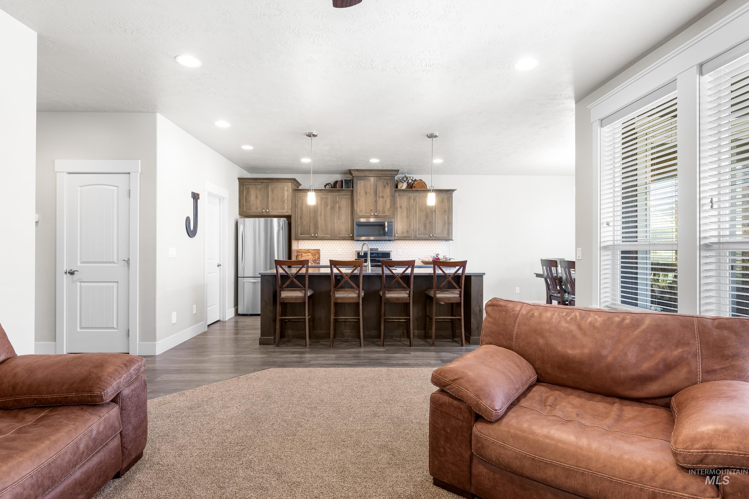 Living room featuring recessed lighting and dark wood-style flooring