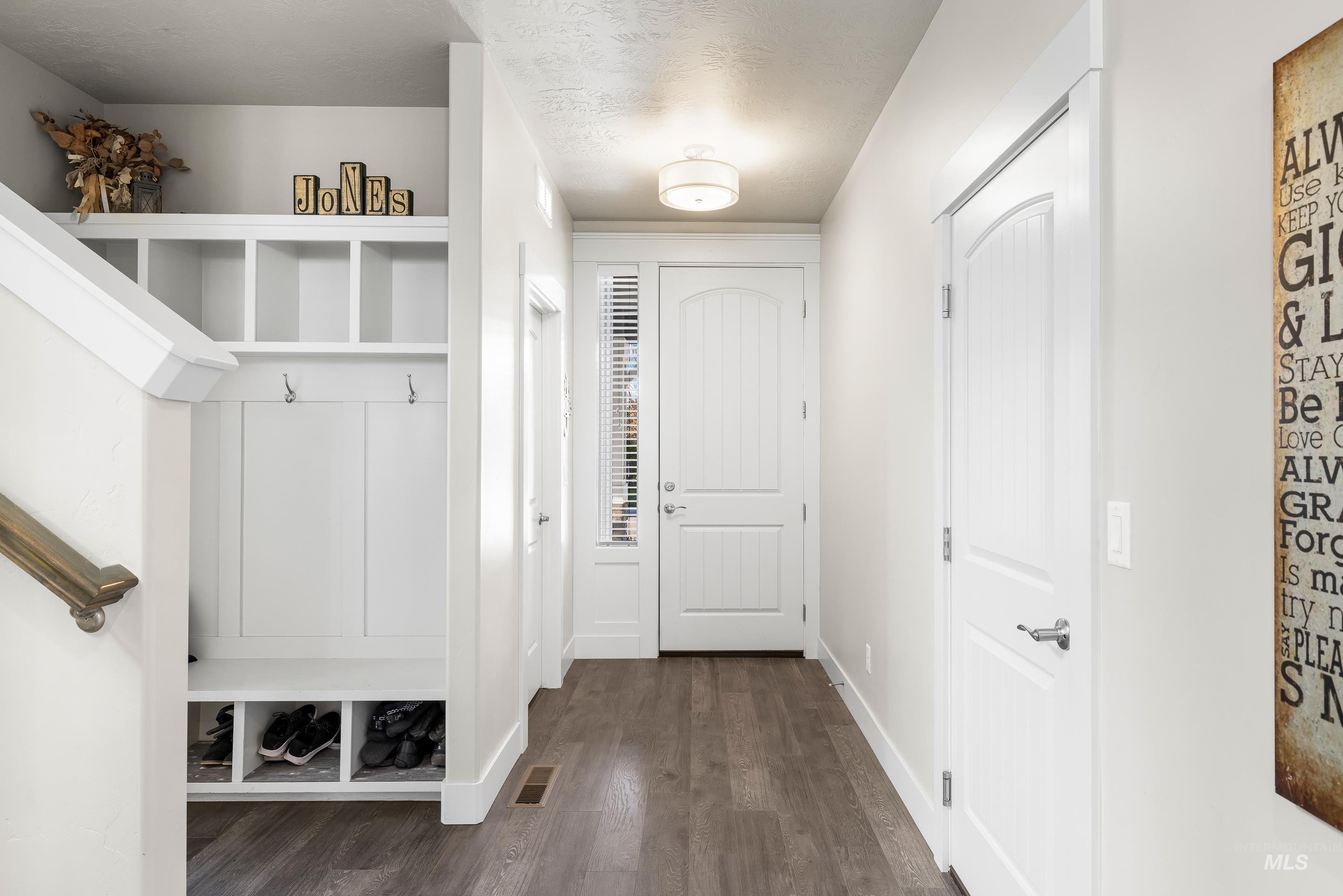 Mudroom featuring dark wood-style floors and a textured ceiling