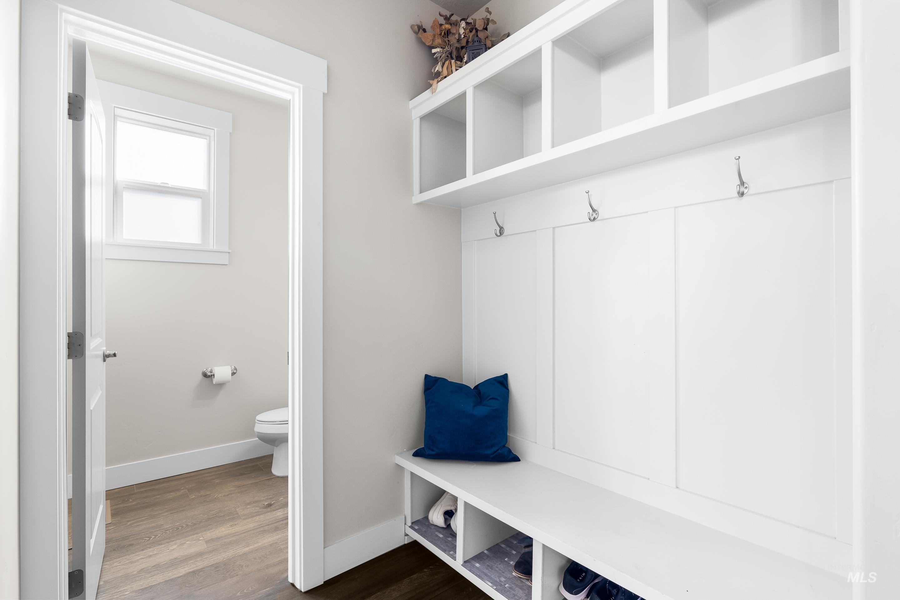 Mudroom featuring dark wood-style flooring and baseboards