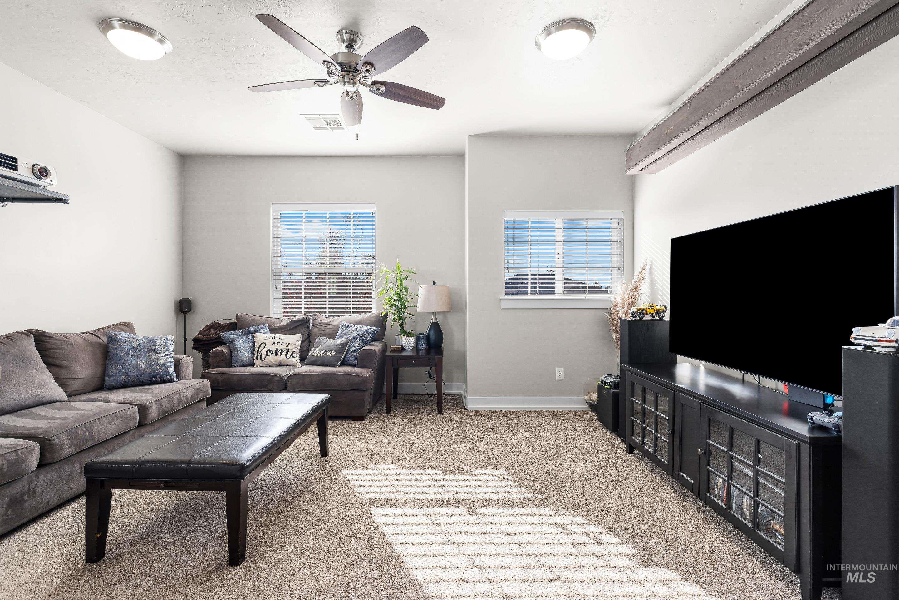 Living room with light carpet and a ceiling fan