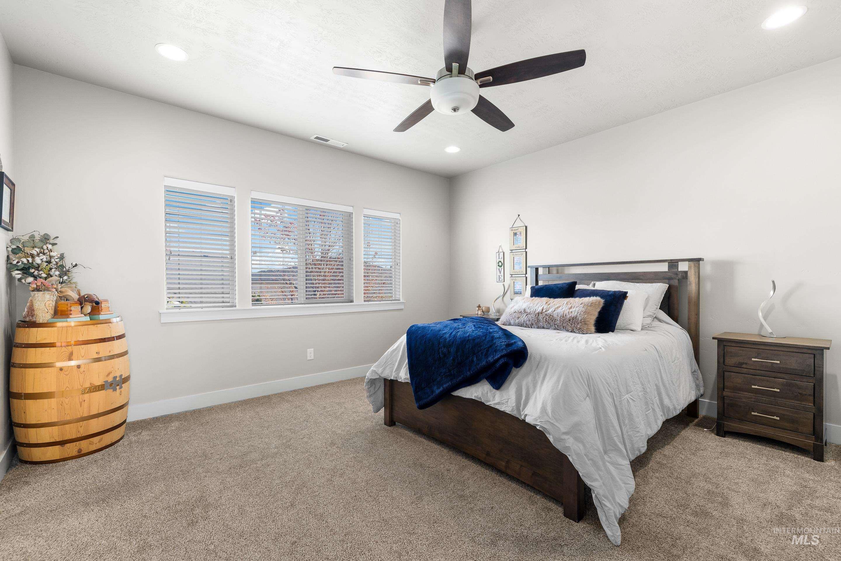 Carpeted bedroom featuring recessed lighting and a ceiling fan