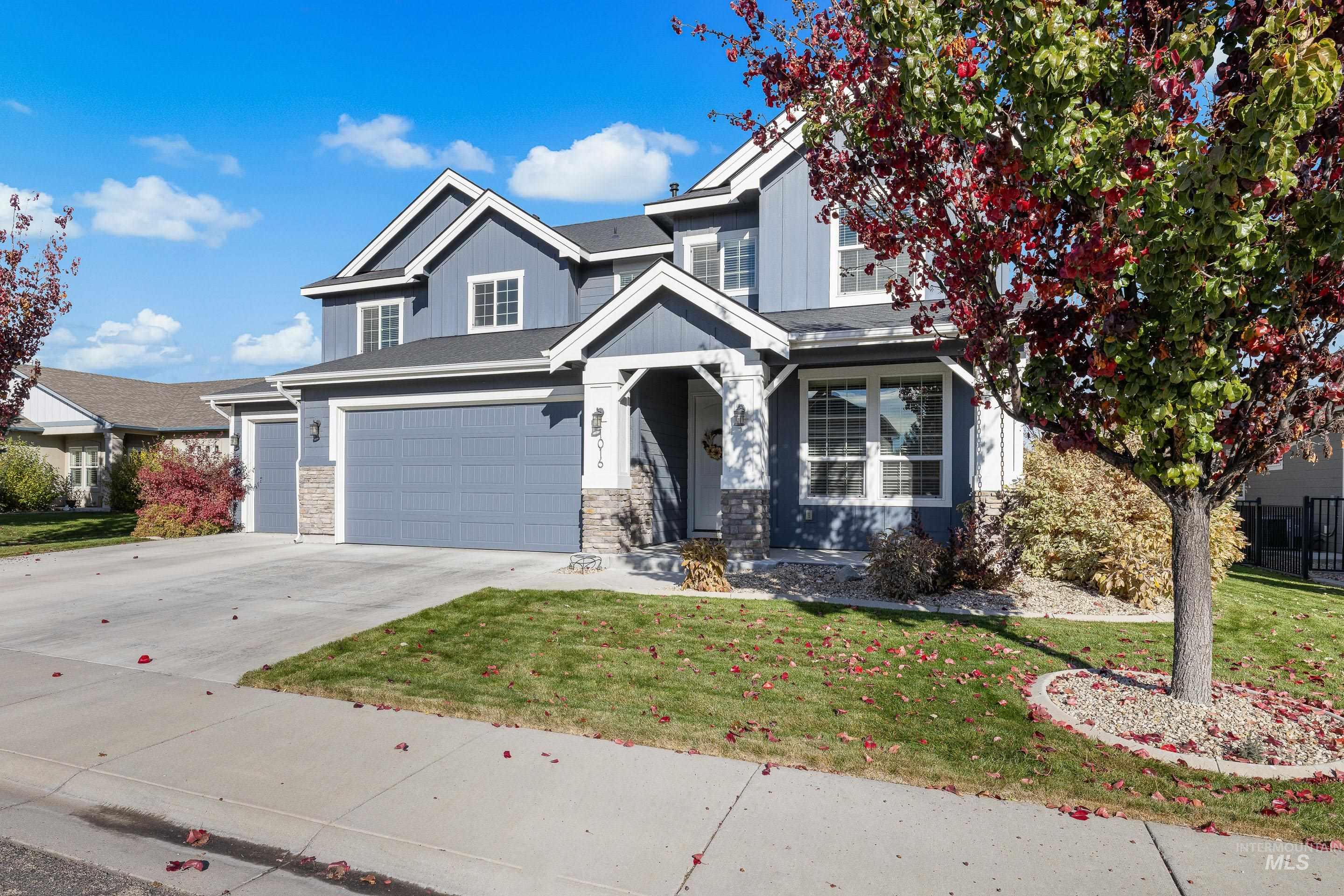 View of front of home with a front yard, concrete driveway, a garage, and board and batten siding