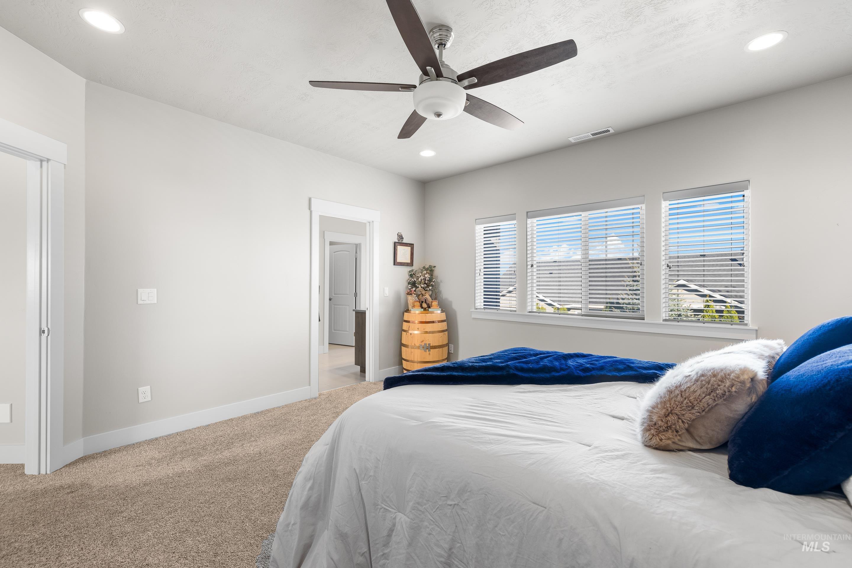 Bedroom with light colored carpet, recessed lighting, and ceiling fan