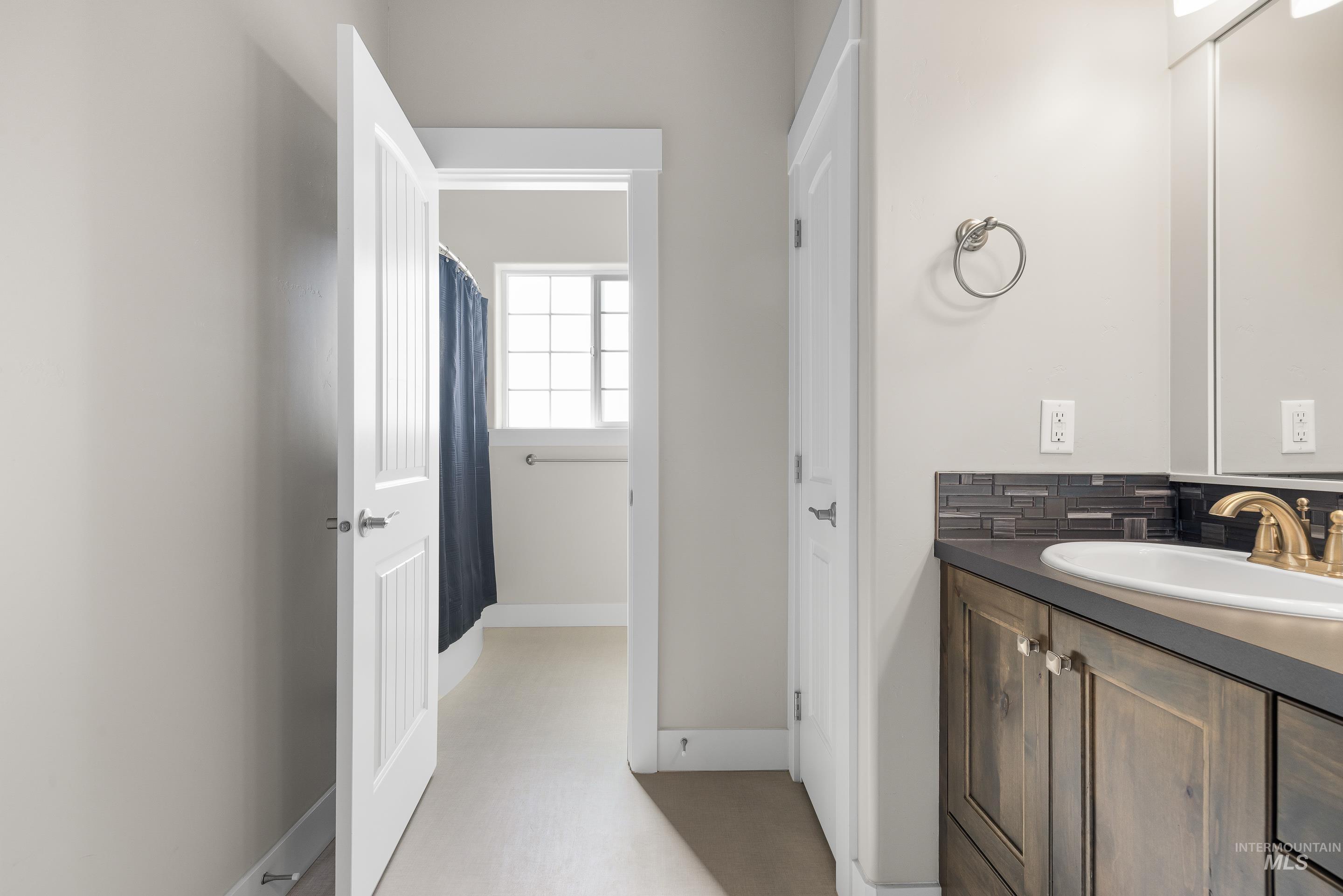 Bathroom with vanity, backsplash, and a shower with curtain