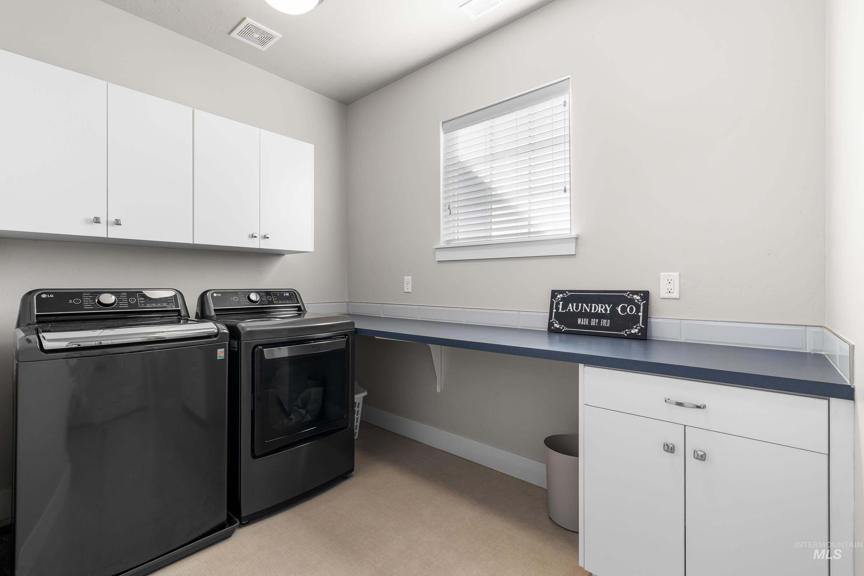Washroom with cabinet space and washing machine and dryer