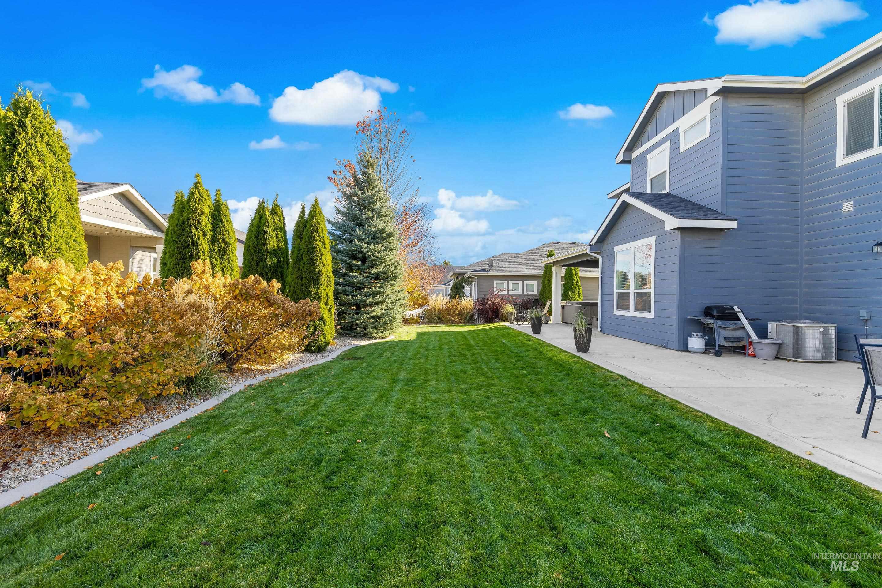 View of grassy yard featuring a patio