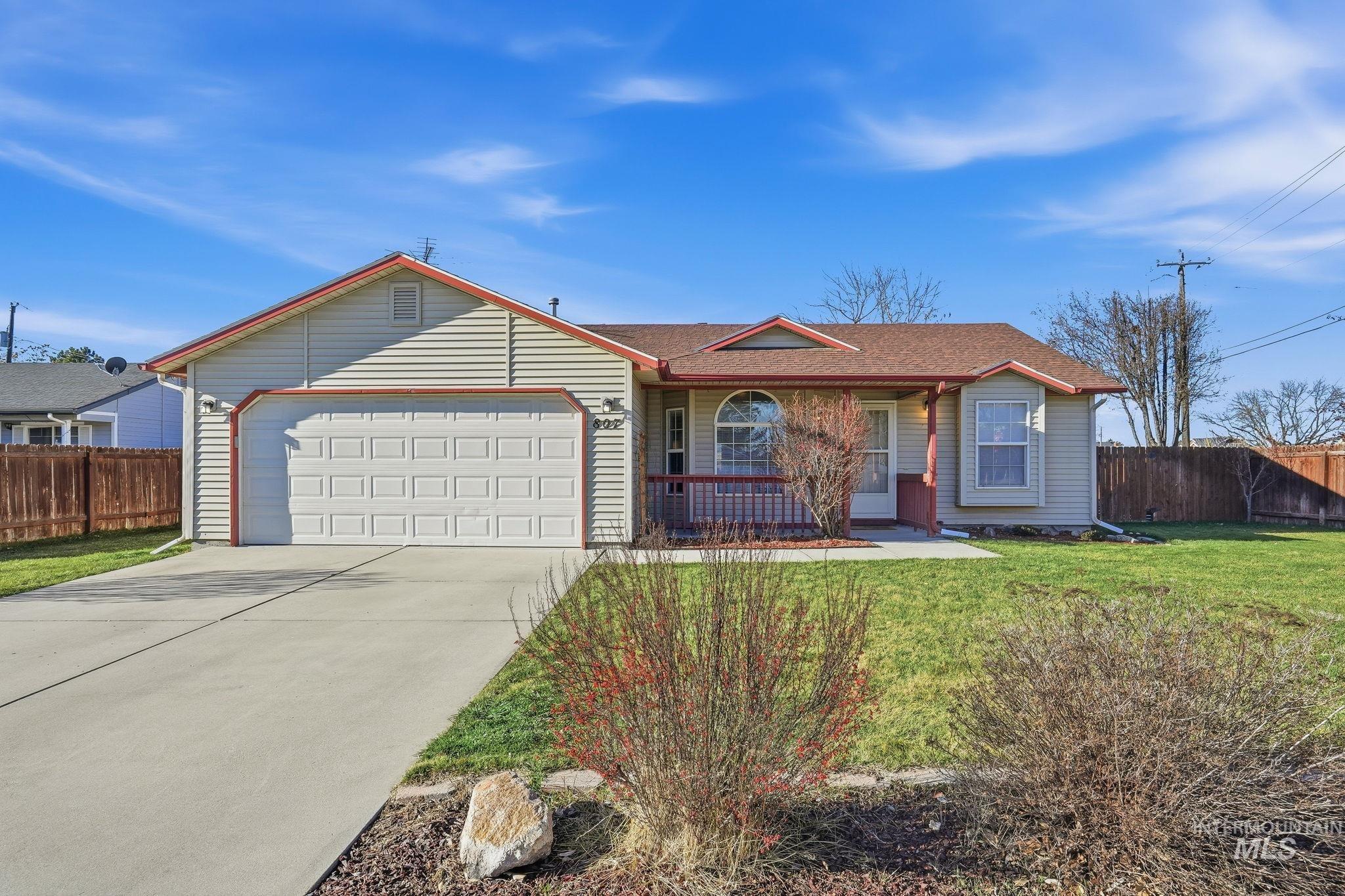 Ranch-style house featuring driveway, a garage, roof with shingles, and a porch