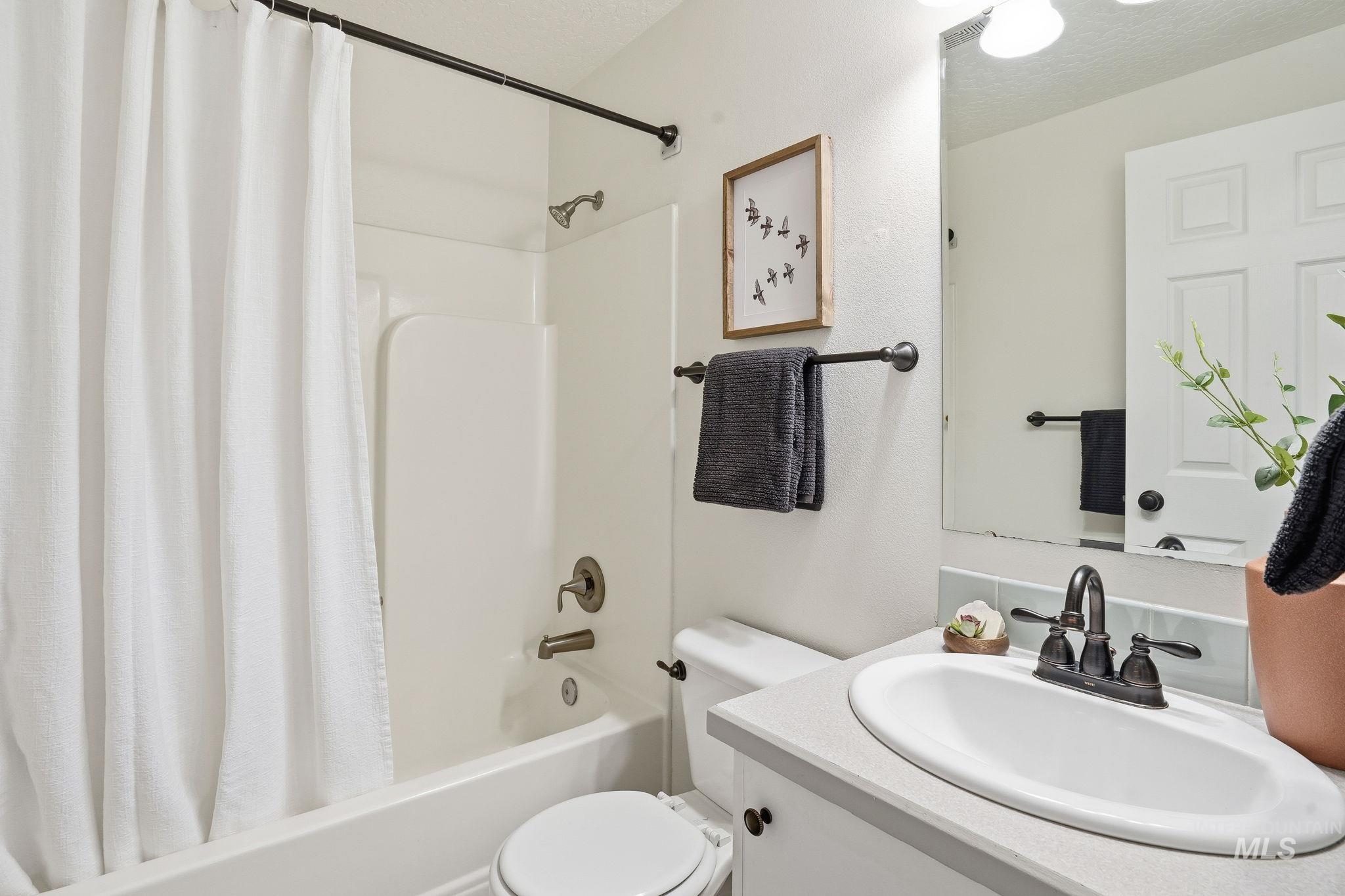 Full bathroom featuring shower / tub combo with curtain and vanity