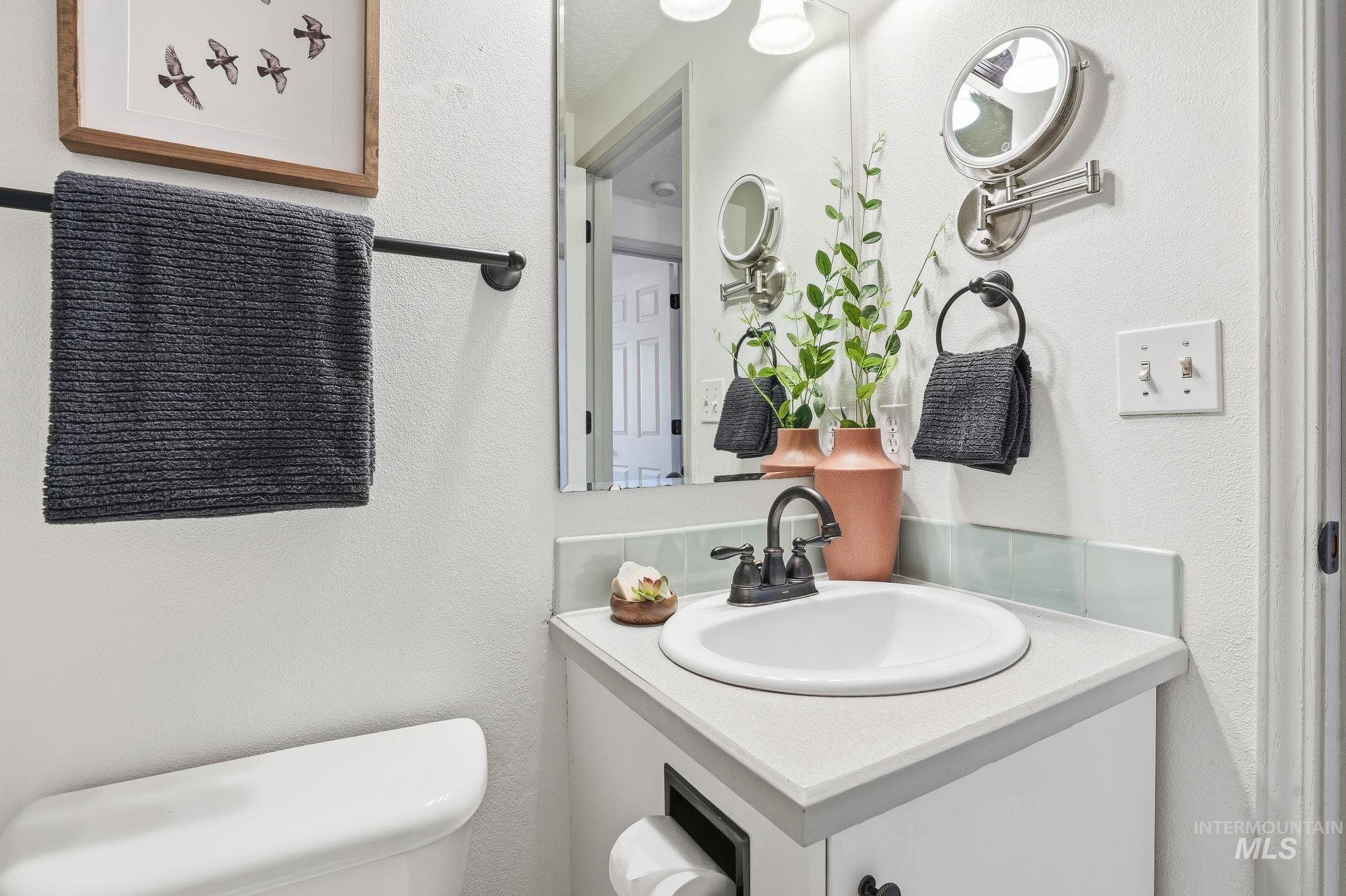 Half bathroom featuring a textured wall and vanity
