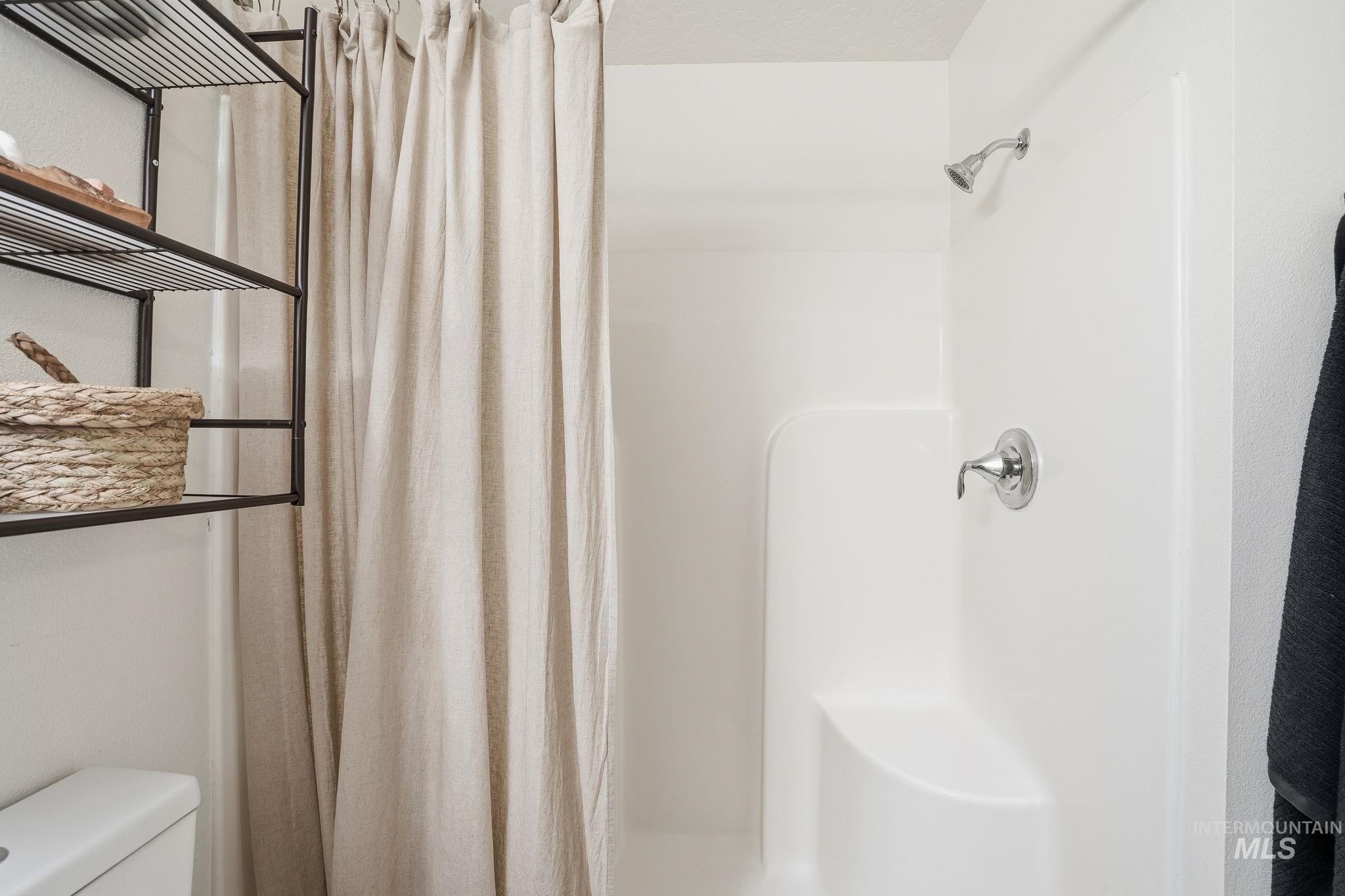 Bathroom featuring a shower with curtain and toilet
