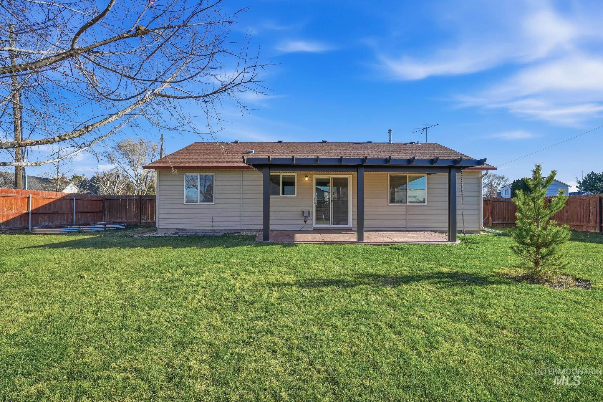 Back of property with a patio area, a fenced backyard, and a shingled roof