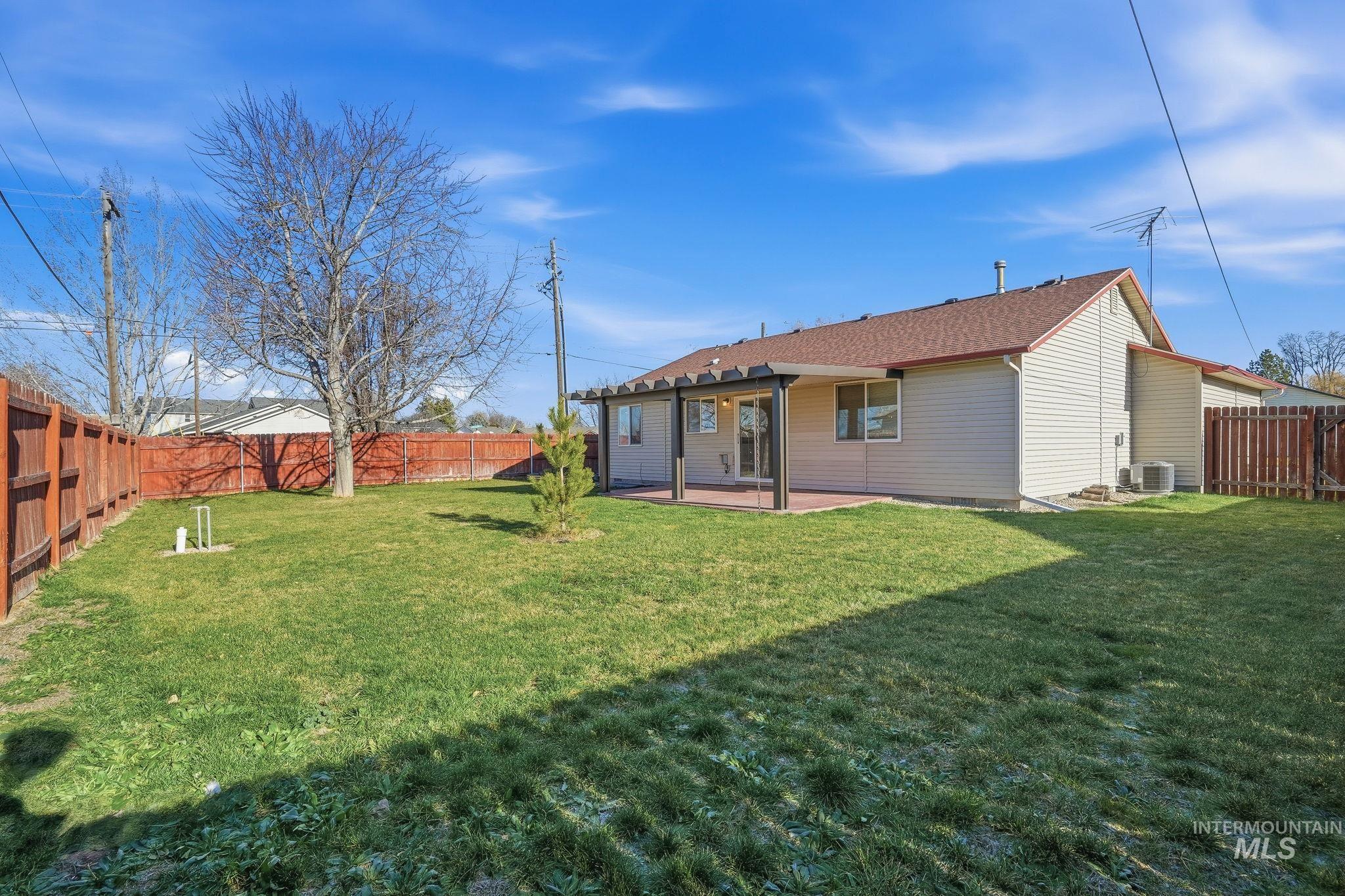 Back of property with a patio, a fenced backyard, and a shingled roof