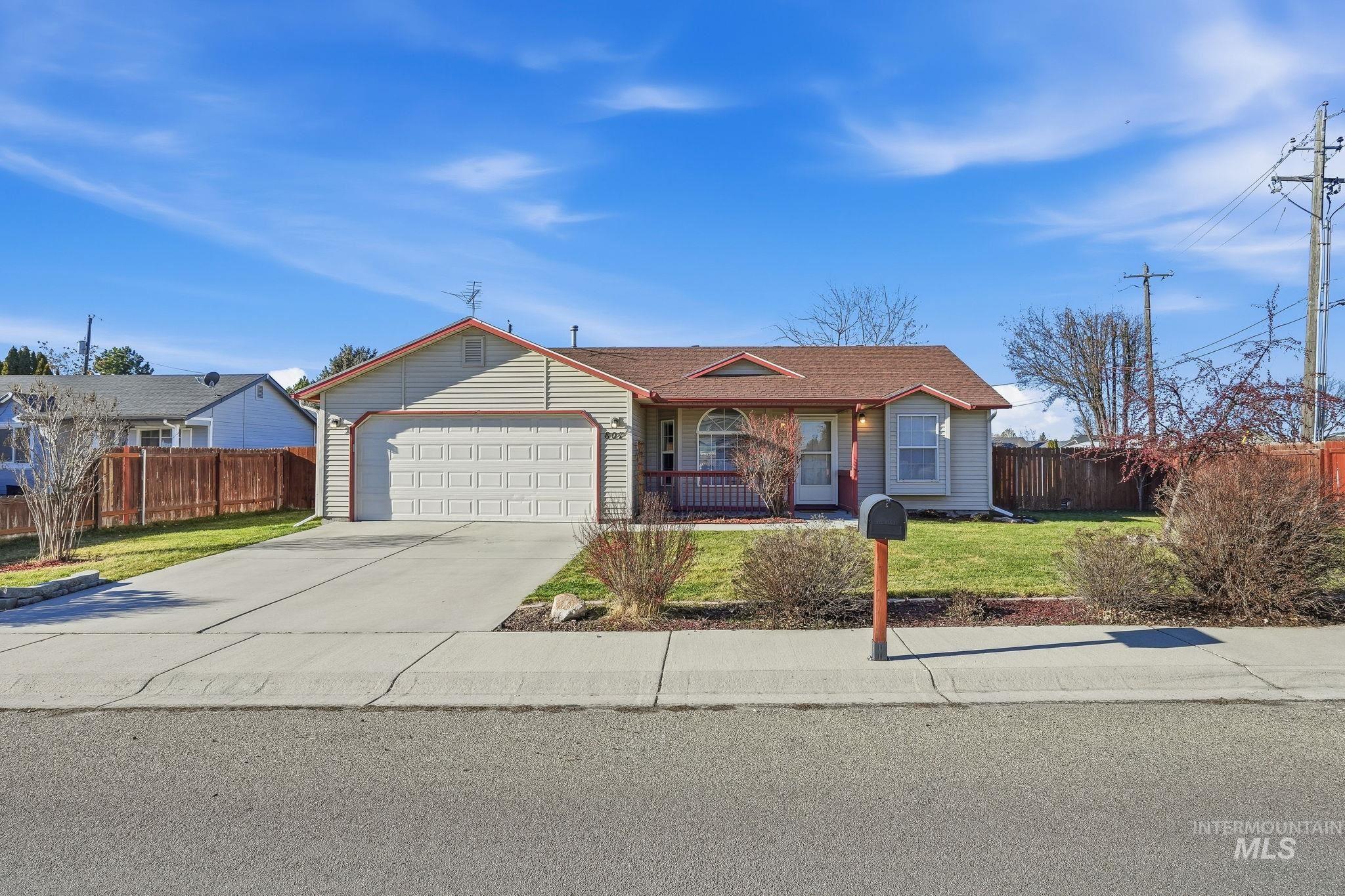 Ranch-style home with driveway, an attached garage, and covered porch