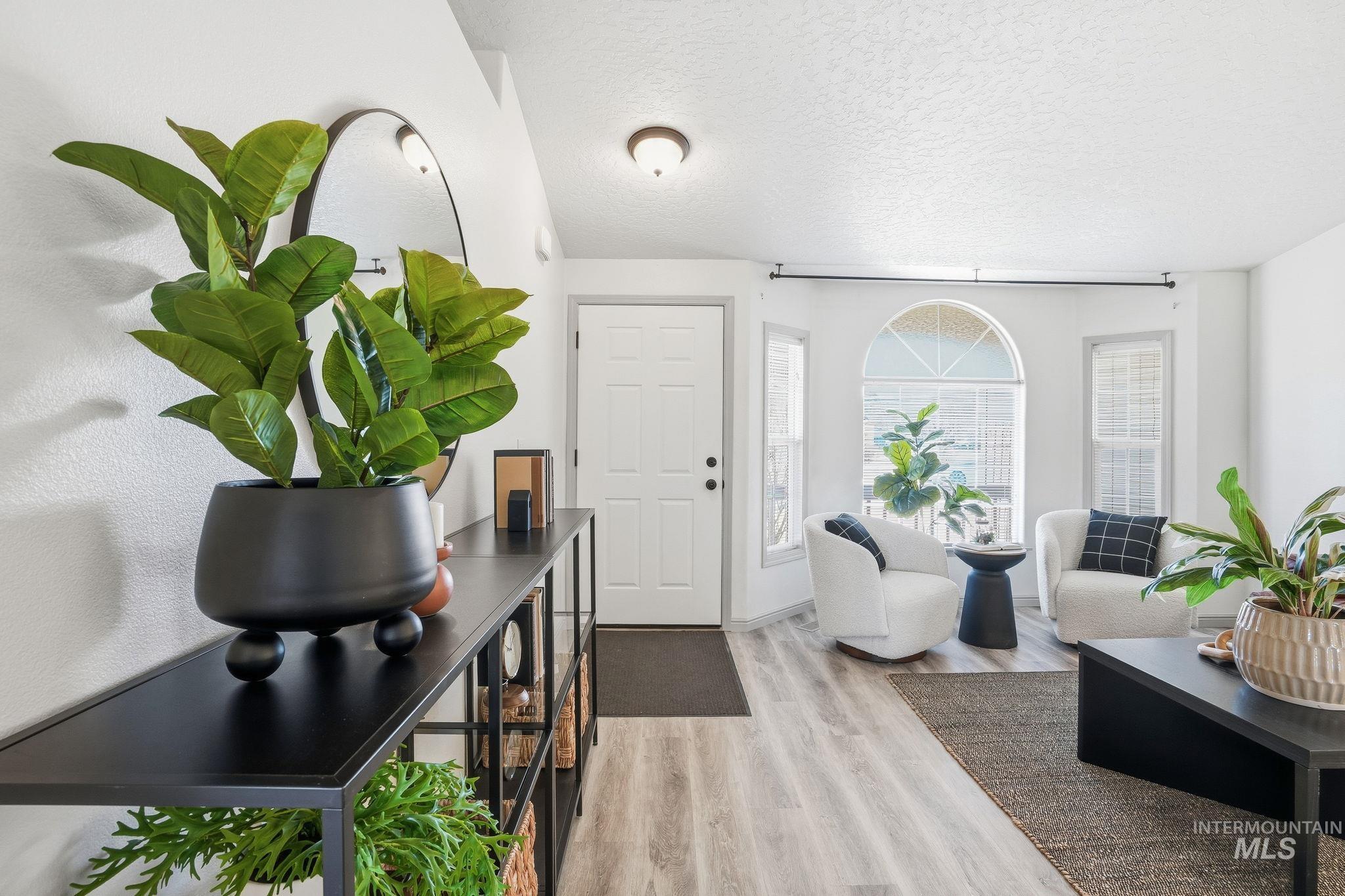 Foyer with a textured ceiling and light wood-style floors