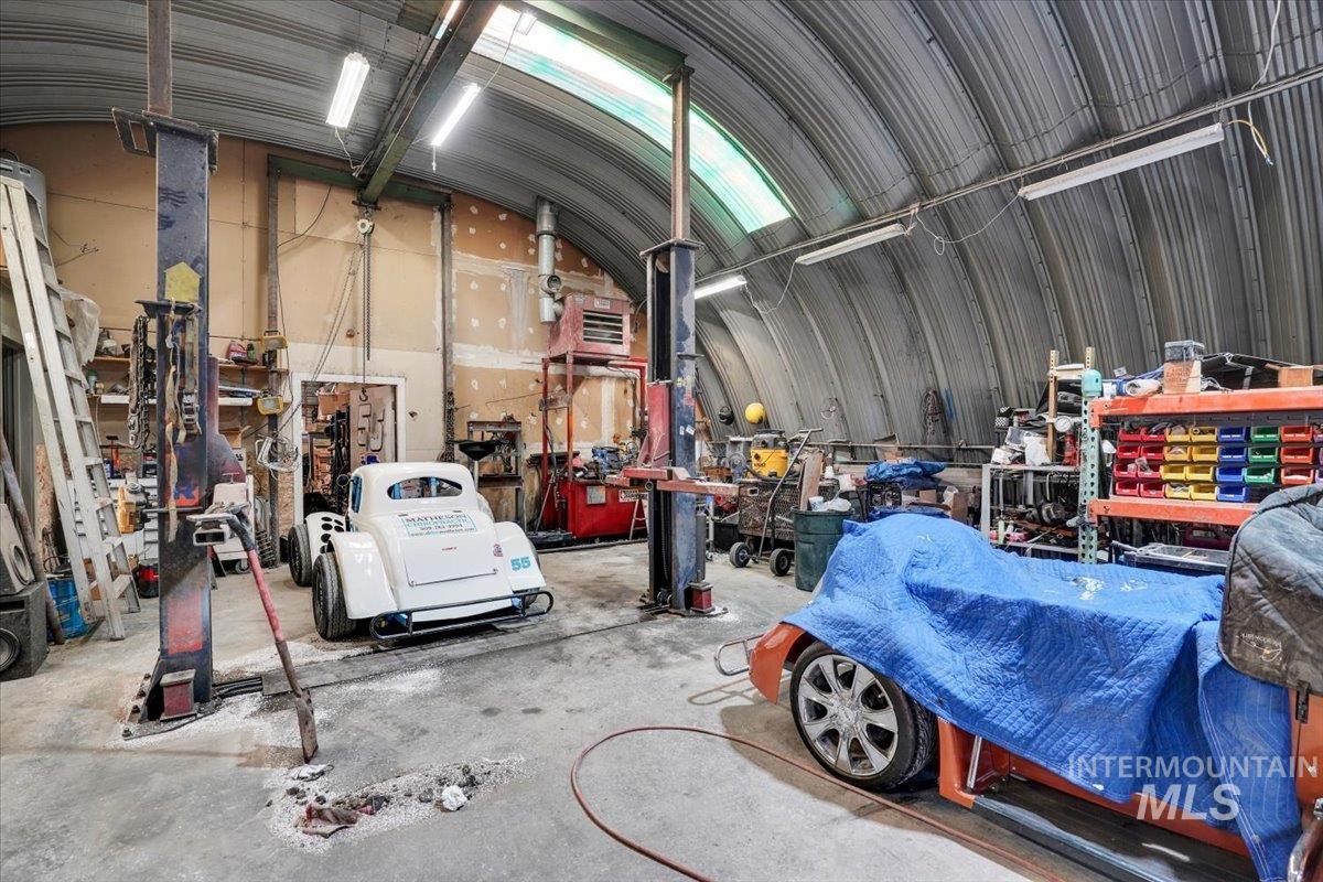 Garage featuring a workshop area, metal wall, and a heating unit