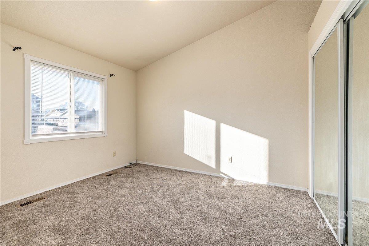 Unfurnished bedroom featuring a closet, lofted ceiling, and carpet flooring