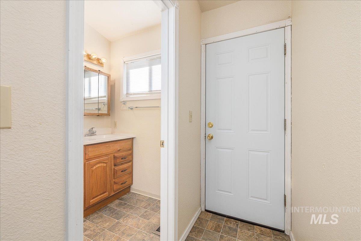 Bathroom featuring vanity, stone finish flooring, and a textured wall