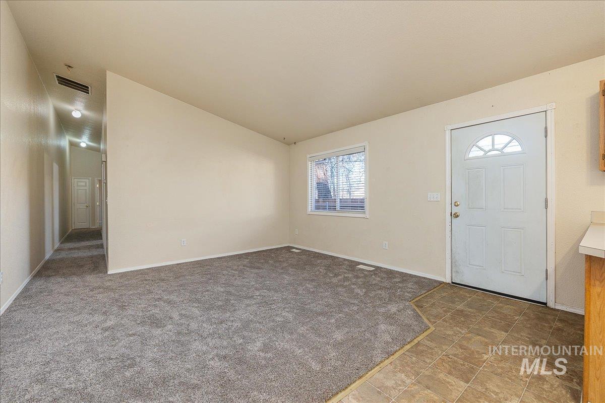 Entrance foyer featuring vaulted ceiling and light carpet
