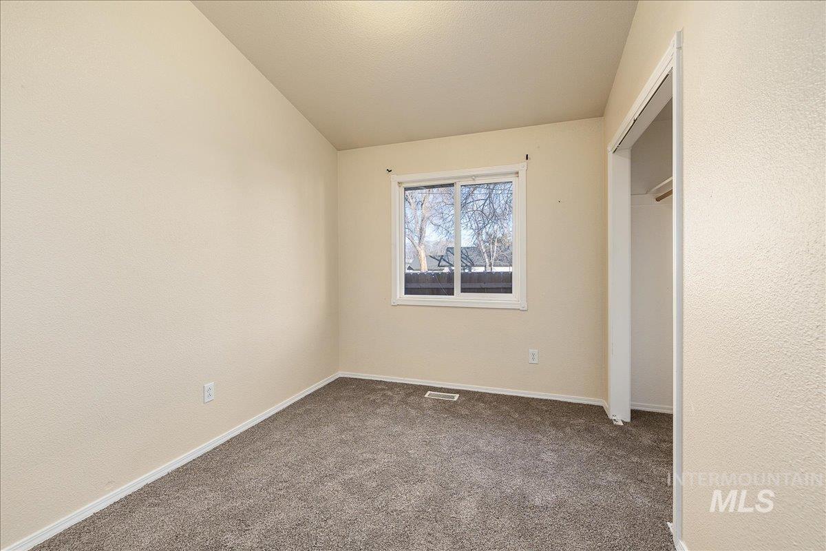 Unfurnished bedroom featuring carpet, a closet, and a textured wall