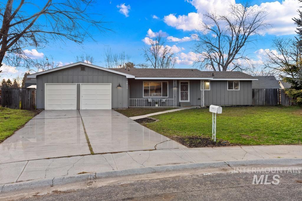 Ranch-style house with a porch, concrete driveway, a garage, board and batten siding, and a shingled roof