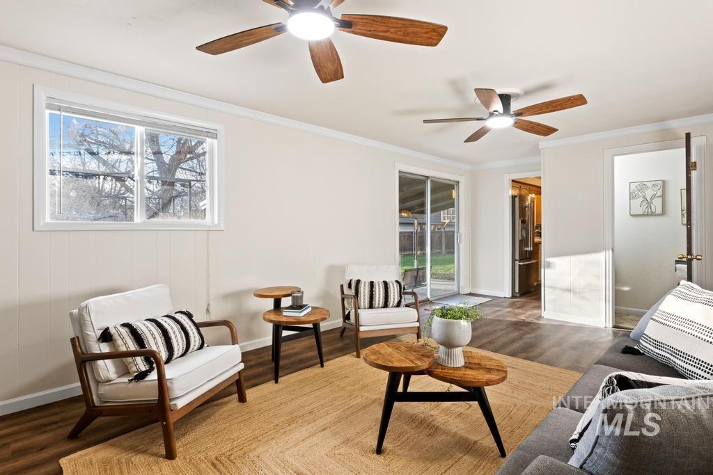 Living area featuring crown molding, wood finished floors, and a ceiling fan