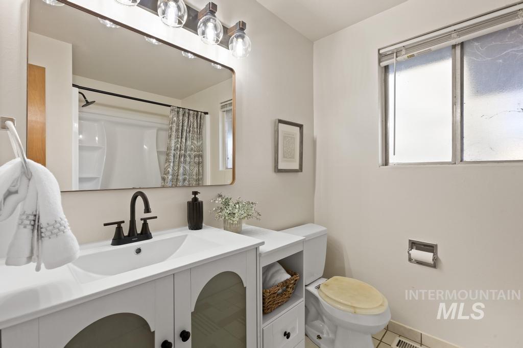 Bathroom with vanity, curtained shower, and tile patterned flooring